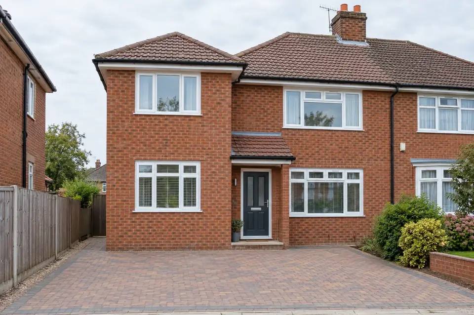 Two-storey side extension on a red-brick semi with brickwork and hipped roof matched to the house