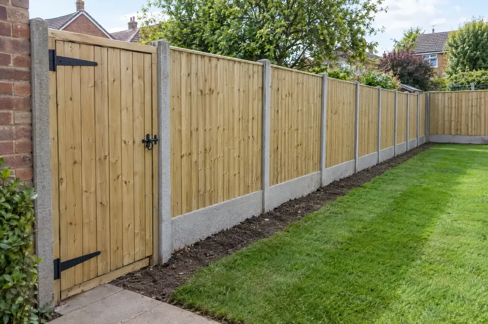 New closeboard fence with concrete posts and gravel boards and a matching timber side gate
