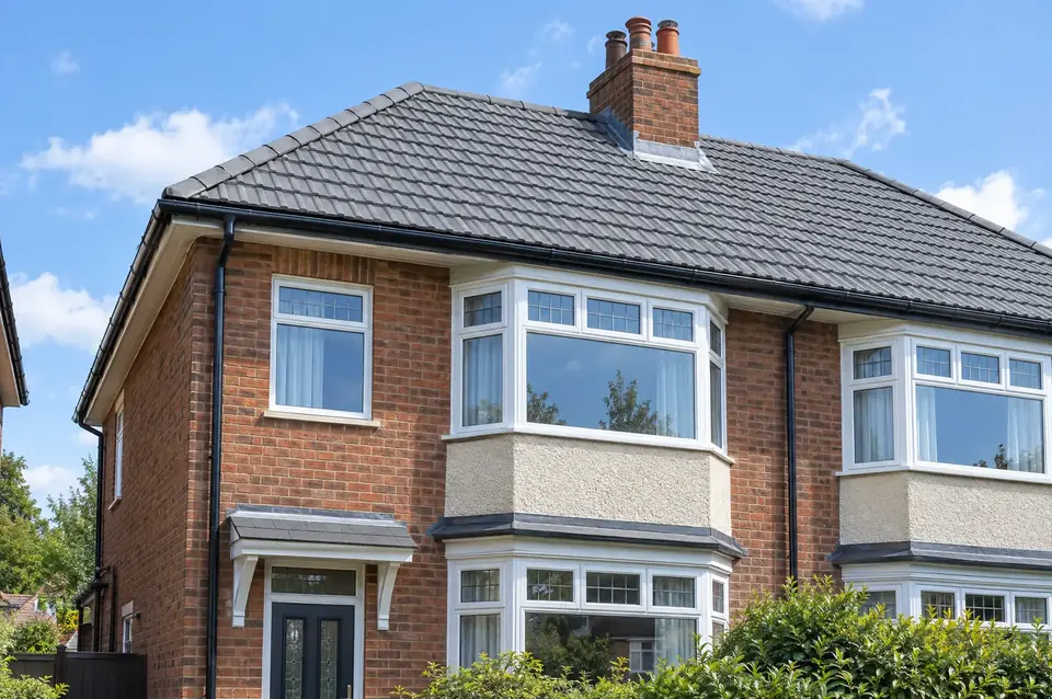 Freshly re-roofed semi-detached house with new grey concrete tiles and lead chimney flashing
