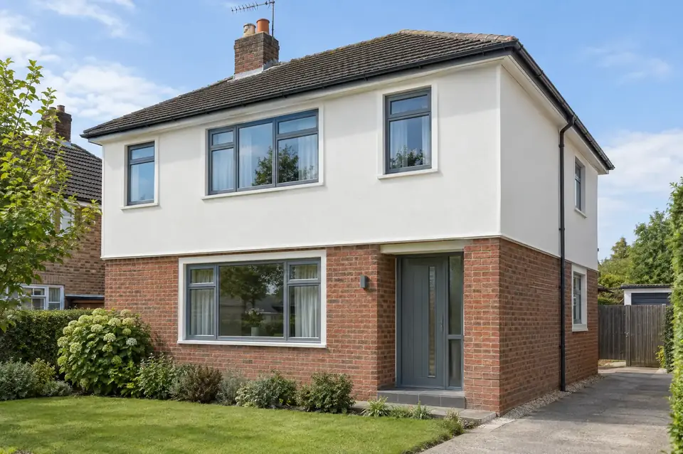 House with fresh off-white silicone render on the upper floor above the original brickwork