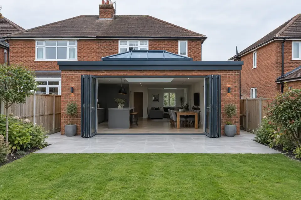 Single-storey rear extension with a roof lantern and open anthracite bi-fold doors onto a porcelain patio
